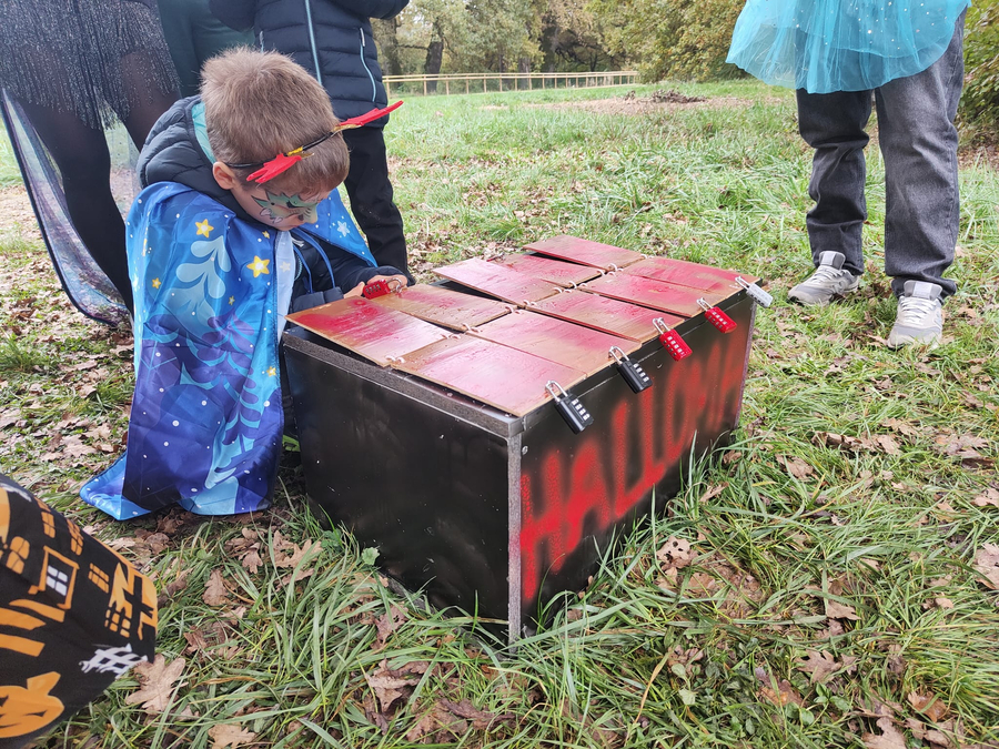 Enfant tentant d’ouvrir un coffre lors d’une animation à Hallomania aux Evaux.